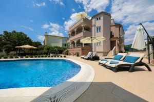 a villa with a swimming pool in front of a building at Apartments Tony in Biograd na Moru
