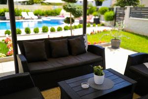 a patio with a couch and a table and a pool at Apartments Tony in Biograd na Moru