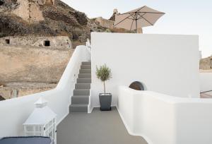 a staircase in a white room with a potted plant at Santo Castello in Akrotiri