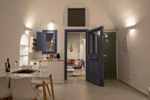 a kitchen and dining room with a blue door and a table at Santo Castello in Akrotiri