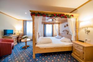 Schlafzimmer mit Himmelbett und Weihnachtsdekoration in der Unterkunft Hotel Alpbach in Meiringen