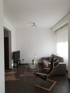 a living room with a couch and a chair at B&B Stadio Apartment in Pordenone