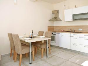 una cucina con tavolo e sedie in una stanza di Modern apartment in Ljubac with private terrace a Ljubač
