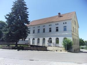 un grand bâtiment blanc avec un arbre en face dans l'établissement Luna et Sol - Haus Am See Seeblick-Apartment, à Seehausen