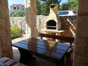 a wooden bench sitting on a patio with a pizza oven at Casa Emma in Krk