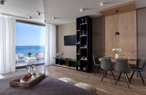 a living room with a bed and a table with a view at Seafront Apartments by Myseasight in Hersonissos