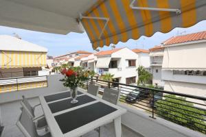 a table with a vase of flowers on a balcony at Villa Repas in Pefkochori