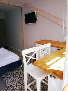 ドゥシュニキ・ズドルイにあるDolceのテーブル、椅子、ベッドが備わる客室です。
