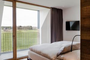 ein Schlafzimmer mit einem Bett und einem großen Fenster in der Unterkunft Hotel Lenderstuben in Balzhausen