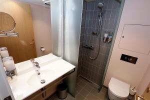 a bathroom with a shower and a sink and a toilet at Hotel Bethel in Copenhagen