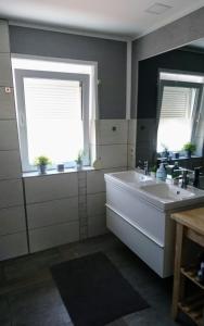 a bathroom with a tub and a sink and two windows at Ferienzimmer am Berzdorfer See Görlitz OT Tauchritz in Görlitz +17 photos