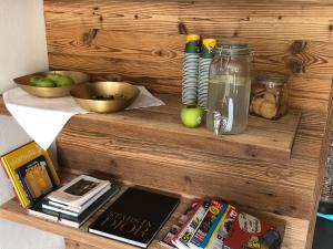 ein Holzregal mit Büchern, einer Schale Äpfel und einem Glas Saft in der Unterkunft Villa Baltia in Graal-Müritz