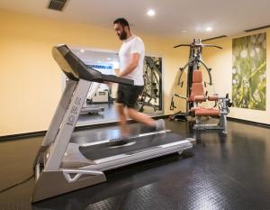 un hombre corriendo en una cinta de correr en un gimnasio en Flemings Hotel Wuppertal-Central en Wuppertal