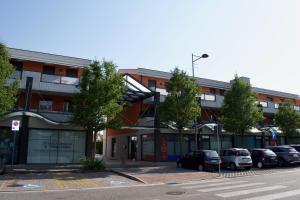 a building with cars parked in a parking lot at App4rent Family Apartment 3 camere, 2 bagni, Wi-Fi, animali ammessi in Jesolo