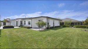 een wit huis met een gazon ervoor bij 7*7 holiday home in Christchurch