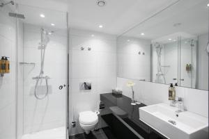 a bathroom with a sink, toilet and bathtub at Flemings Express Hotel Wuppertal in Wuppertal