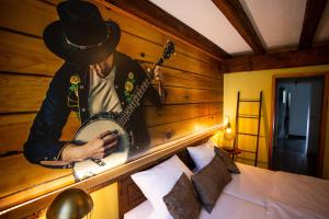 a man with a hat playing a guitar in a bedroom at VILLA CANTARE in Obernburg am Main