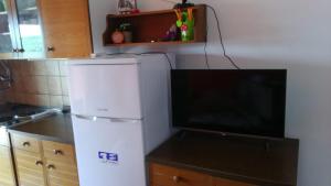 Il comprend une cuisine équipée d'un réfrigérateur blanc et une télévision à écran plat. dans l'établissement Studio Apartment Jadranko, à Krnica