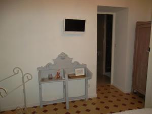 een kamer met een tafel en een tv aan de muur bij Aux Roses de l'Etang in Capestang