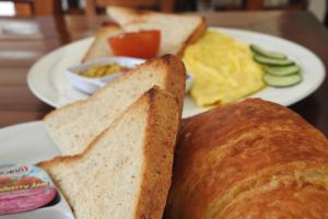a plate of food with bread and scrambled eggs at D'Batur Hotel in Senggigi 