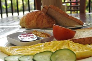 a plate of breakfast food with eggs and bread at D'Batur Hotel in Senggigi 