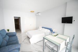 a living room with a bed and a table and a couch at Cubo's Estudio Castillo de Santa Clara in Torremolinos