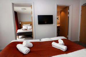 a bedroom with two beds with white towels on a red blanket at Hotel Bethel in Copenhagen