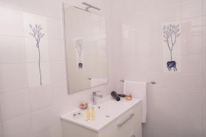 a white bathroom with a sink and a mirror at Fuori le Mura in Paestum +27 photos