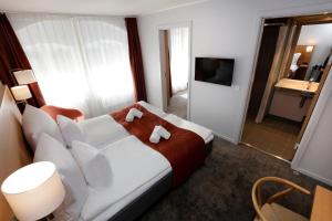 a hotel room with a bed and a television at Hotel Bethel in Copenhagen