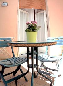 a table with a potted plant and two chairs at Be Inn in Salerno