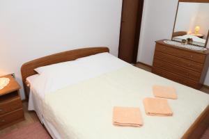ein Schlafzimmer mit einem Bett und eine Kommode mit einem Spiegel in der Unterkunft Apartman Sardelić in Korčula