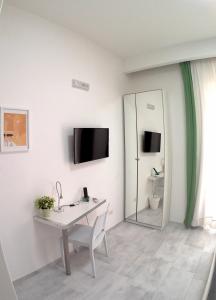 Habitación blanca con escritorio y espejo. en Be Inn, en Salerno