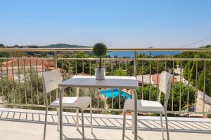 un tavolo e sedie su un balcone con vista sull'oceano di Zorbas Family House ad Agia Paraskevi