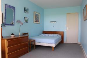 1 dormitorio con paredes azules, 1 cama y vestidor en Saint Philibert à 2 pas de la mer en Saint-Philibert