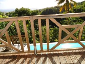 a wooden bridge with a swimming pool on it at villa cocotiers in Sainte-Marie