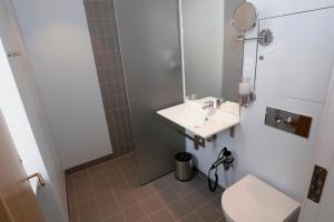 a bathroom with a toilet and a sink and a mirror at Hotel Bethel in Copenhagen