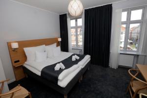 a hotel room with a bed with towels on it at Hotel Bethel in Copenhagen