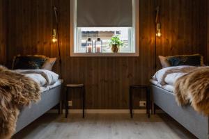 two beds in a room with a window at Aa-Gård in Tennevoll