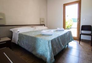 una camera da letto con un letto e due asciugamani di Hotel Eden a Carovigno