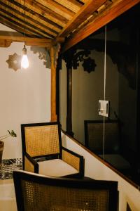 a room with two chairs and a mirror at Baligong Villa in Sukawati