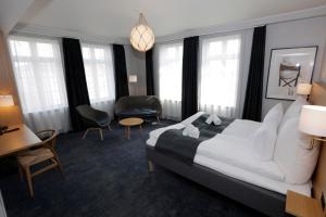 a hotel room with a bed and chairs and windows at Hotel Bethel in Copenhagen