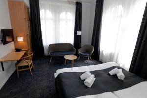 a hotel room with a bed and a desk and chairs at Hotel Bethel in Copenhagen