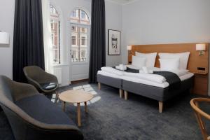 a hotel room with two beds and a couch at Hotel Bethel in Copenhagen