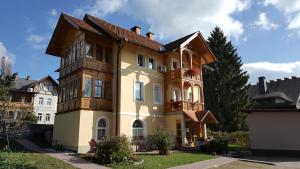 una gran casa amarilla con techo marrón en Vila Julija, en Bled