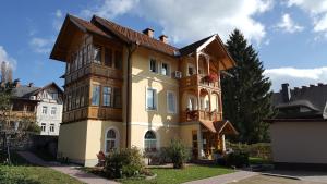 a large yellow house with a brown roof at Vila Julija in Bled +27 photos