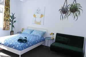 Un dormitorio con una cama y un sofá verde. en Igloo Hybrid, en Nottingham