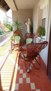 a patio with three chairs and a table on a porch at Erika Apartman in Tihany