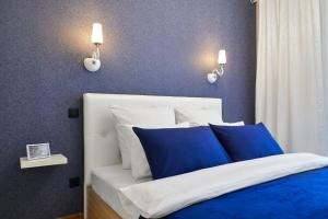 a bedroom with a bed with blue and white pillows at PaulMarie Apartments on Mayakovskogo 35 in Minsk