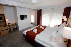 a hotel room with a large bed and a television at Hotel Bethel in Copenhagen