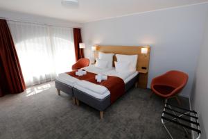 a hotel room with a bed and a red chair at Hotel Bethel in Copenhagen